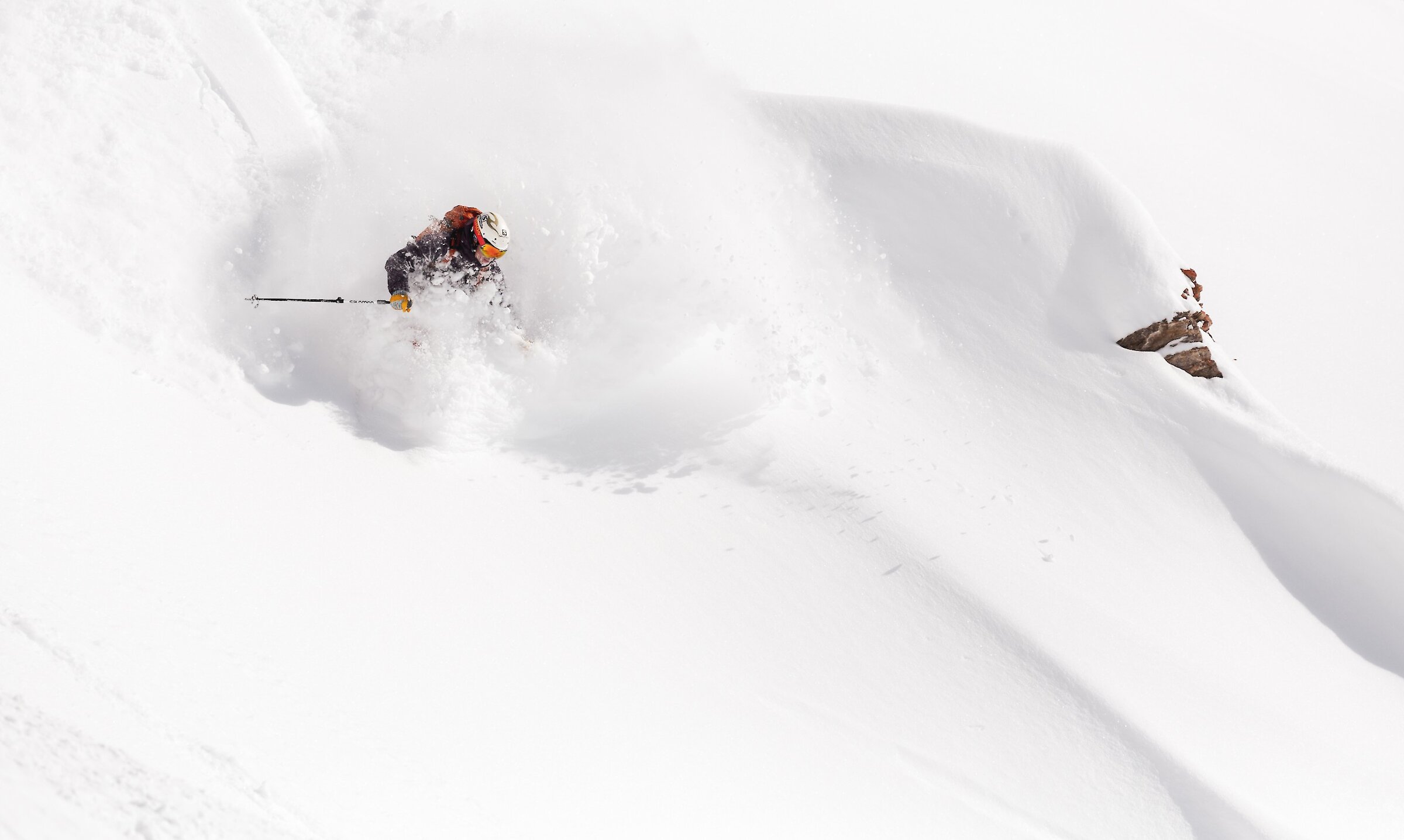 Woman in red jacket skiing down snowy slope